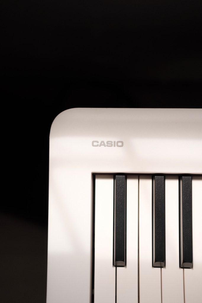 Touches d’un clavier Casio blanc sous une lumière douce