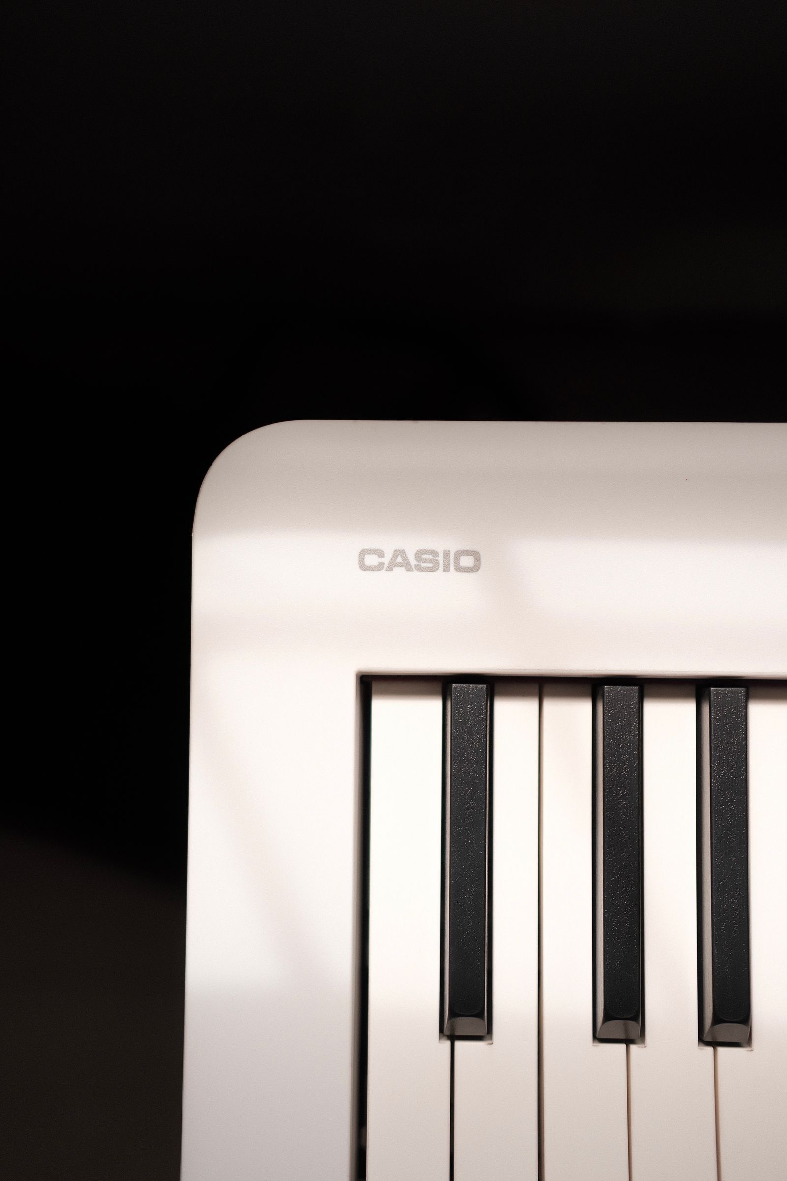 Touches d’un clavier Casio blanc sous une lumière douce