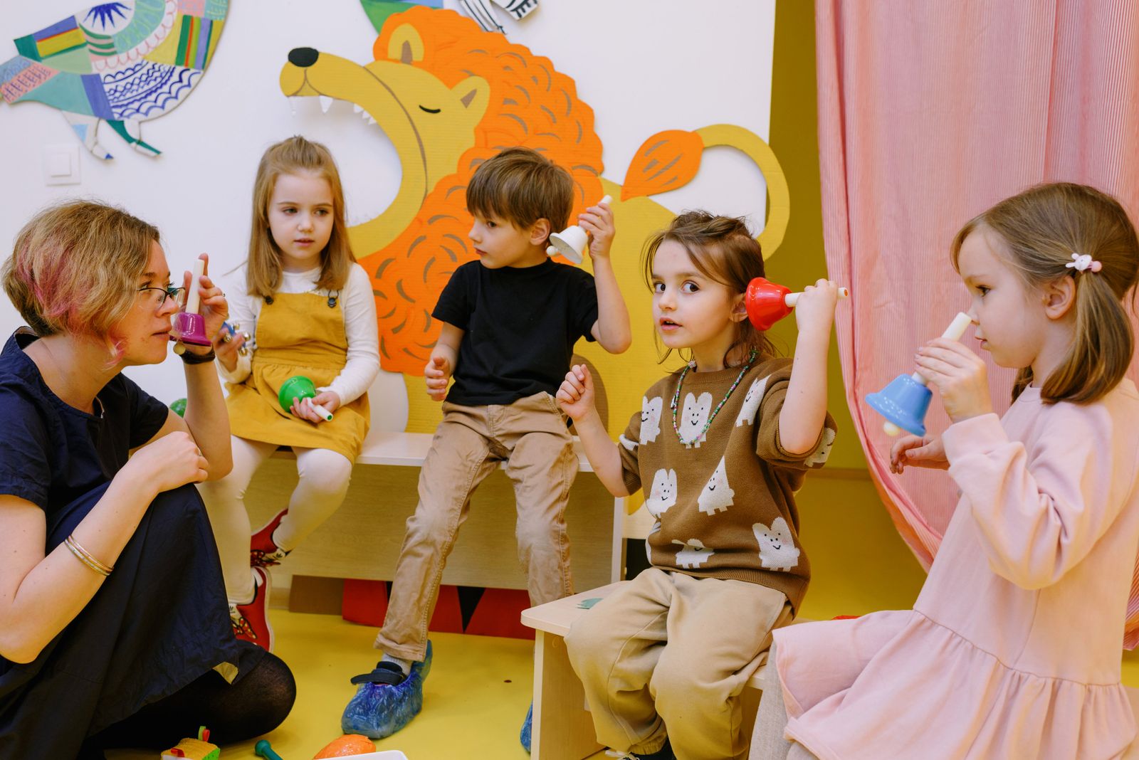 Enfants jouant des cloches avec leur enseignante