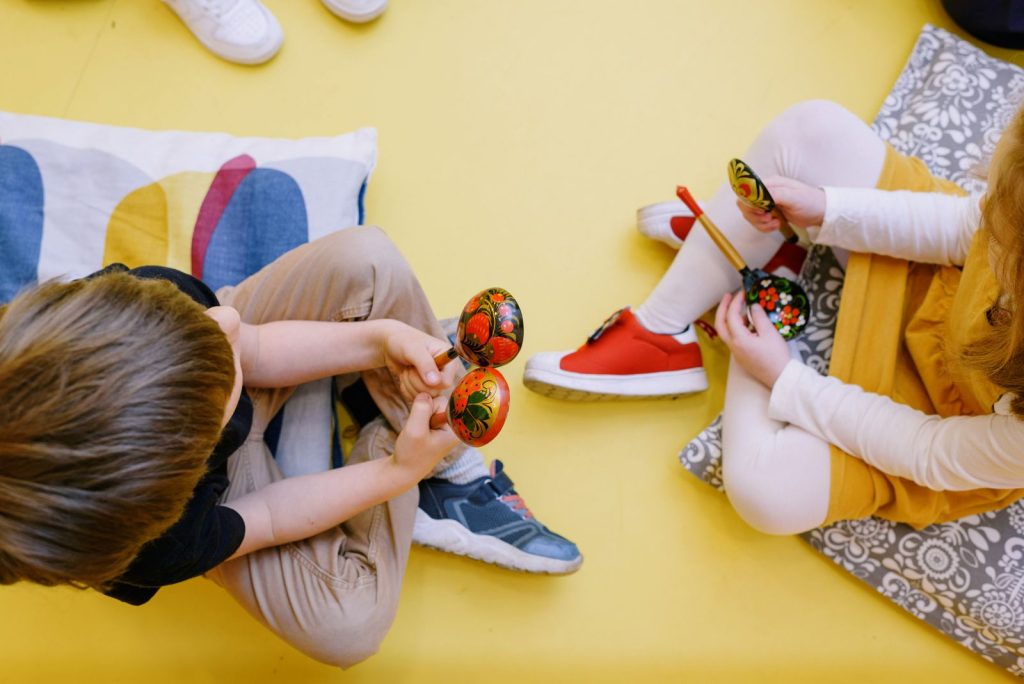 Enfants jouant des maracas dans une salle colorée